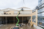 Holzbau-Aufrichtarbeiten: Über der Turnhalle wird das Raumprogramm aufgerichtet
