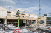 Sicht auf einen verbauten Vierendeelträger während Holzbau-Aufrichtarbeiten